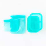Bumkins Silicone Lunchtime 4-Piece Set in Blue Jelly: 3 turquoise bags and 2 matching bento boxes on white background.