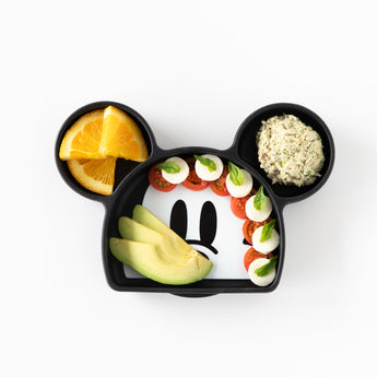 A plate from Bumkins Grip Dish Essential 3-Piece Mealtime Set: Disney Mickey Mouse holds avocado veggies, and more on a white background.