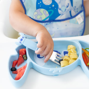 Close-up of a child enjoying pasta and fruit with Bumkins Grip Dish Essential 3-Piece Mealtime Set: Disney Stitch.