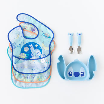 Bumkins Grip Dish Essential 3-Piece Mealtime Set: Disney Stitch lays next to 3 waterproof bibs on a white background.