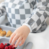 Close-up of a child eating berries and pancakes with Bumkins On-The-Go Mealtime 6-Piece Set: Charcoal Check + Grey.