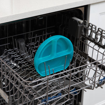 Bumkins Silicone Grip Dish: Blue Jelly sits in the top rack of an open dishwasher.