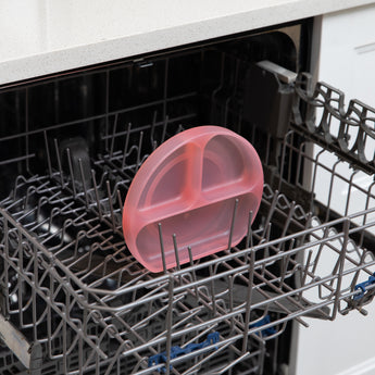 Bumkins Silicone Grip Dish: Pink Jelly sits in the top rack of an open dishwasher.