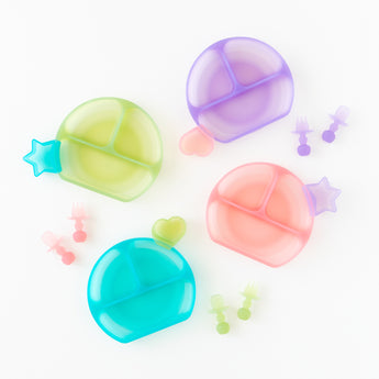 Bumkins Silicone Grip Dish: Pink Jelly sits among other colorful dishes and utensils on a white background.