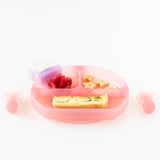Bumkins Silicone Grip Dish: Pink Jelly, filled with berries, bananas, and quiche, a star cup of yogurt, and utensils on a white background.