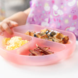 Close-up of a child with a Bumkins Silicone Grip Dish: Pink Jelly filled with scrambled eggs, bacon, and blueberry-topped waffles.
