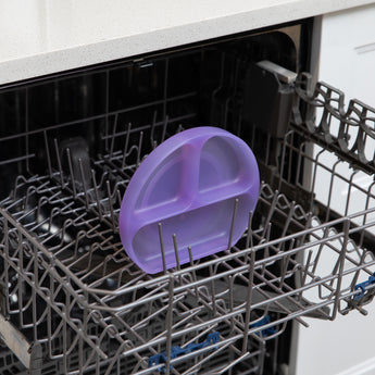 Bumkins Silicone Grip Dish: Purple Jelly sits in the top rack of an open dishwasher.