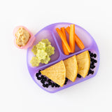 Bumkins Silicone Grip Dish: Purple Jelly holds carrots, cucumbers, beans, and tortillas with a heart cup of hummus on a white background.