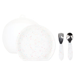 Bumkins Grip Plate Essential 4-Piece Mealtime Set: Vanilla Sprinkle includes a white round silicone dish, white utensils, & a transparent lid.