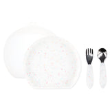 Bumkins Grip Plate Essential 4-Piece Mealtime Set: Vanilla Sprinkle includes a white round silicone dish, white utensils, & a transparent lid.
