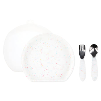 Bumkins Grip Plate Essential 4-Piece Mealtime Set: Vanilla Sprinkle includes a white round silicone dish, white utensils, & a transparent lid.