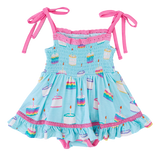 The Harlow Smocked Birdie Twirl by Birdie Bean is a blue dress with pink straps, a cake pattern, and ruffled edges. Breathable fabric.