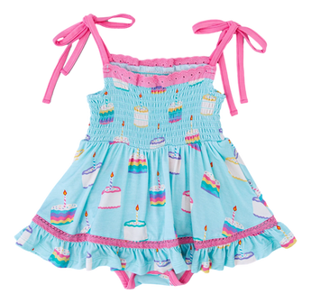 The Harlow Smocked Birdie Twirl by Birdie Bean is a blue dress with pink straps, a cake pattern, and ruffled edges. Breathable fabric.