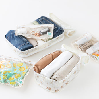 Close-up of Bumkins The Outfit Organizer Essential 5-Piece Set: Palm Daze with clothes, shoes, toiletries, and keys on a white background.