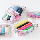 Close-up of Bumkins The Outfit Organizer Essential 5-Piece Set: Boots with clothes, makeup, and toiletries on a white background.