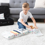 A young boy packs clothes into the Bumkins Packing Cube + Clear Travel Bag Set: Disney Mickey & Friends Varsity by his suitcase.