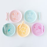 Bumkins Silicone Plate + Spoon Set: Disney Mickey Mouse sits among other similar plate and spoon sets on a white background.