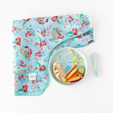 Bumkins Silicone Plate + Spoon Set: Disney Princess Ariel, holding hummus, carrots, and cucumber, sits beside a bib on a white background.
