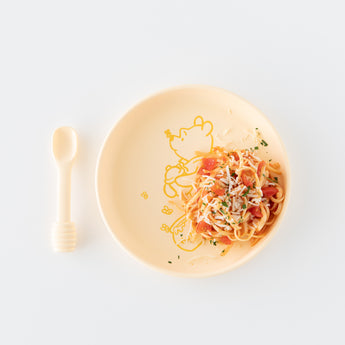 Pasta with red sauce on Bumkins Silicone Plate + Spoon Set: Disney Winnie the Pooh, set against a white background.