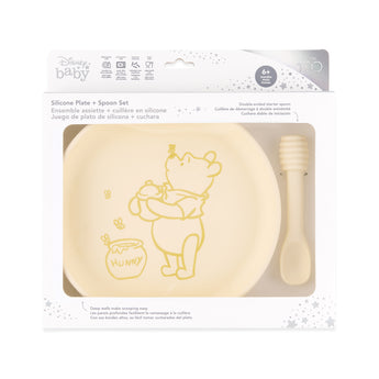 Bumkins Silicone Plate + Spoon Set: Disney Winnie the Pooh is shown in a packaging box, with a clear window displaying the plate and spoon.