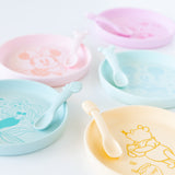 Bumkins Silicone Plate + Spoon Set: Disney Winnie the Pooh sits on a white background next to other similar plate sets.