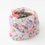 A bag from Bumkins The Playdate Planner Deluxe 5-Piece Set: Boots sits on a white background with groceries and canned goods inside.