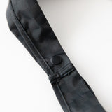 Close-up of the Bumkins Packable Tote Bag: Rich Black on a white background, showcasing the snap button closure on the straps.