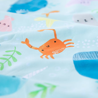 Close-up of Bumkins Reversible Roll & Go Blanket, Rolling with the Waves, with a sea creature design on soft recycled fabric.
