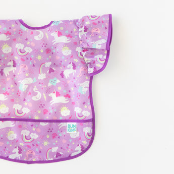 A bib from Bumkins Snack In Style 3-Piece Set: Unicorns and Rainbows lays flat on a white background.