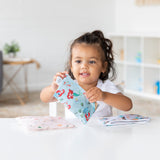 A girl opens bags from Bumkins Snack In Character 4-Piece Set: Disney Princess Magic Tiana at a white table.