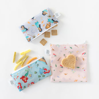 Bags from Bumkins Snack In Character 4-Piece Set: Disney Princess Magic Belle with snacks and a sandwich rest on a white background.