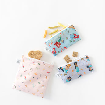Bags from Bumkins Snack In Character 4-Piece Set: Disney Princess Magic Tiana hold snacks and a sandwich on a white background.