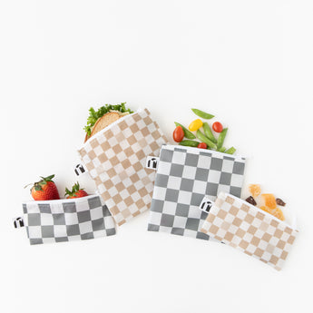 Roamio by Bumkins Reusable Snack Bag 4 Pack: Double Check lays overlapped on a white background with a sandwich, fruit, & veggies inside.
