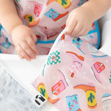 Close-up of a Roamio by Bumkins Reusable Snack Bag, Large 2 Pack: Disco Boots held by a child wearing a matching bib.
