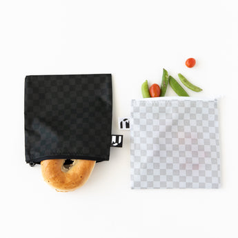Roamio by Bumkins Reusable Snack Bag, Large 2 Pack: Rich & Boujee holds a bagel, tomatoes, and pea pods on a white background.