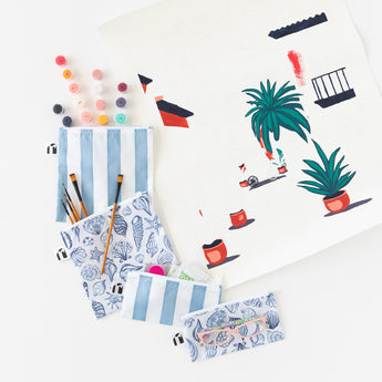 Roamio by Bumkins Snack Bag 4 Pack: Coastal lays fanned out on a white background with paints & brushes peeking out next to a painting.
