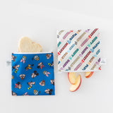 Bumkins Reusable Snack Bag, Large 2 Pack: Mickey & Friends MVP lays on a white background with a heart-shaped sandwich & apple slices inside.