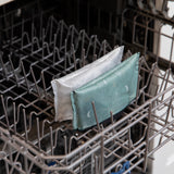 Bumkins Reusable Snack Bag, Small 2 Pack: Desert Night sits in the top rack of an open dishwasher.