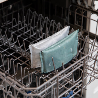 Bumkins Reusable Snack Bag, Small 2 Pack: Desert Night sits in the top rack of an open dishwasher.