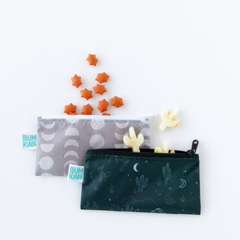 Bumkins Reusable Snack Bag, Small 2 Pack: Desert Night, with star and cactus shaped crackers spilling out, lays on a white background.