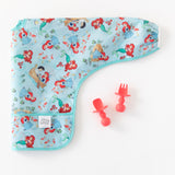 A colorful baby bib with Ariel is paired with Bumkins Silicone Chewtensils®: Red on a white background.