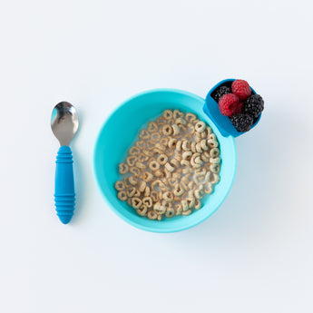 A blue bowl of cereal with milk and berries, plus Bumkins Spoon + Fork: Dark Blue—perfect for toddlers learning utensils.