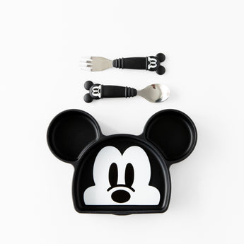 A plate and toddler utensils from Bumkins On-The-Go Mealtime 7-Piece Set: Mickey & Friends MVP rest on a white background.