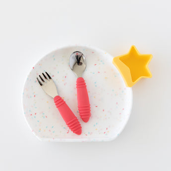 Bumkins plate with Spoon + Fork: Red in food-safe silicone and a star-shaped cup on a white surface.