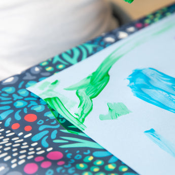 Close-up of a painted piece of paper on a Bumkins Splat Mat: Animal Prints.