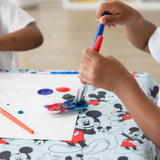 Child painting on a Mickey Mouse Splat Mat by Bumkins, crafted from waterproof and machine washable fabric.