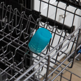 A cup from Bumkins Baby-Led Weaning Deluxe 7-Piece Set: Blue sits in the top rack of an open dishwasher.