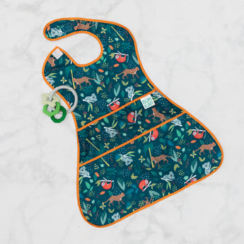 Bumkins Super-Sized SuperBib®: Jungle lays flat on a marble background with a green teething toy.