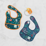 Bumkins Starter Bib 2 Pack: Jungle & Animal Prints lays flat next to an orange teething toy on a marble background.