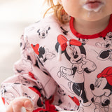 Close-up of a child with a messy mouth wearing a Bumkins Sleeved Bib: Minnie Mouse covered with yogurt drops.